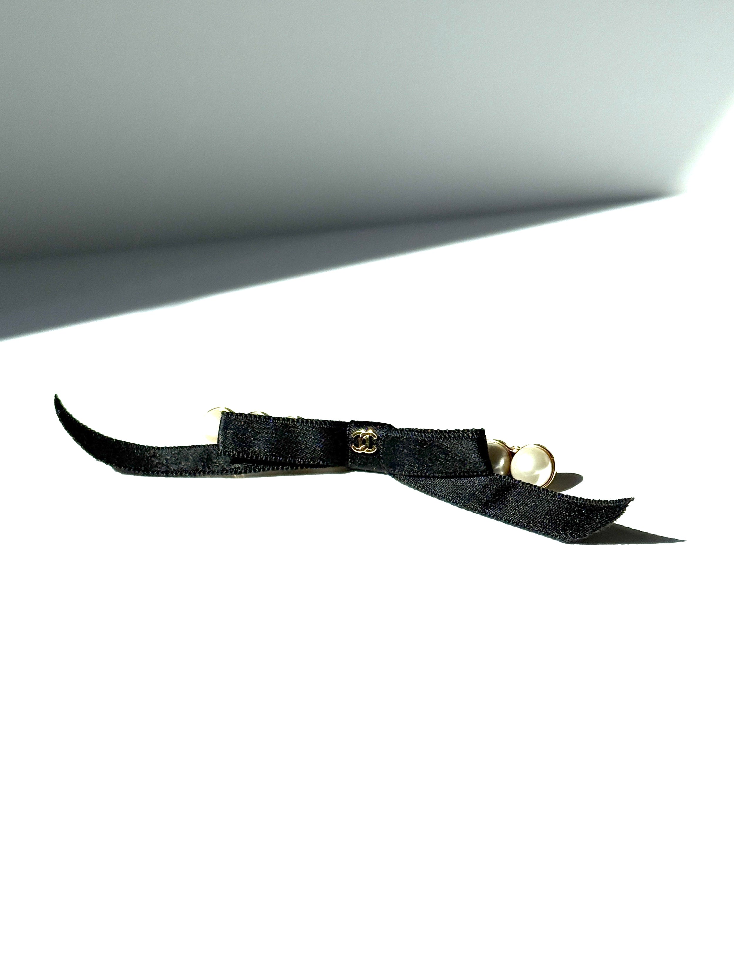 CHANEL Black Faux Pearl Bow CC Logo 2025 Gold hardware Hair Barrette Clip